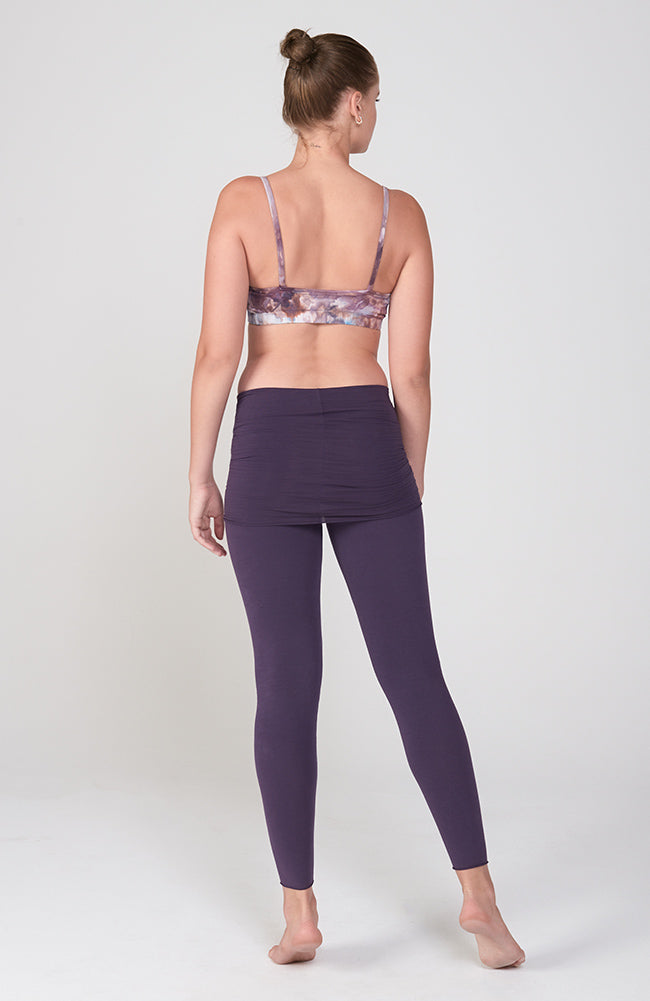 back view of our strappy cami bralete in ice dye swirls of purple and light blue. shown with the Nomad skirted legging in deep purple.
