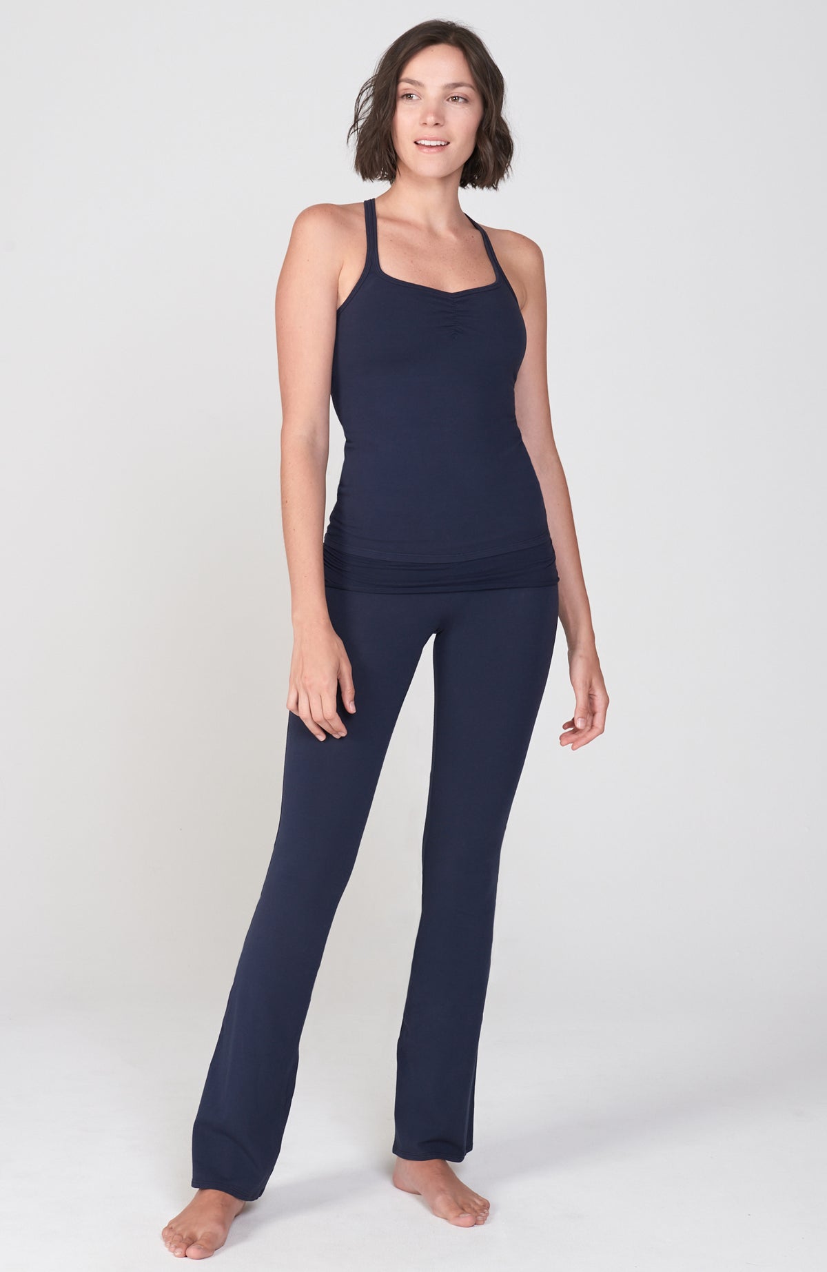fitted Navy Blue Organic cotton lycra bootcut Activewear pant with flare leg. Shirred detail waist overlay. shown with matching Navy Racerback workout tank.